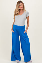 woman wearing a grey short sleeve top and blue wide leg maternity pants with pockets