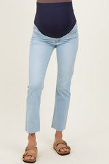 woman wearing light wash maternity jeans with a dark navy over-the-bump band and frayed hem