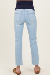 woman wearing light blue maternity jeans with a fitted waistband and cropped hem, showing the back view