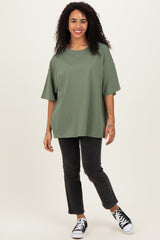 woman wearing an oversized army green t-shirt and black straight-leg jeans with black sneakers