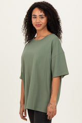 woman wearing a loose-fitting olive green oversized t-shirt with short sleeves and a round neckline