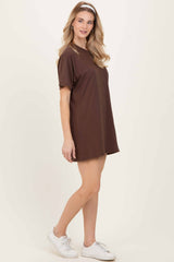 woman wearing a brown short sleeve t-shirt dress styled with a headband and white sneakers
