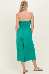 woman wearing a green strapless jumpsuit with a gathered back and wide legs