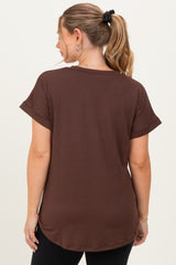 woman wearing a brown short sleeve maternity top, viewed from the back, with relaxed fit and rolled sleeves