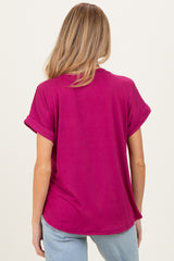 woman wearing a fuchsia short sleeve maternity top, seen from the back, with rolled sleeves and relaxed fit