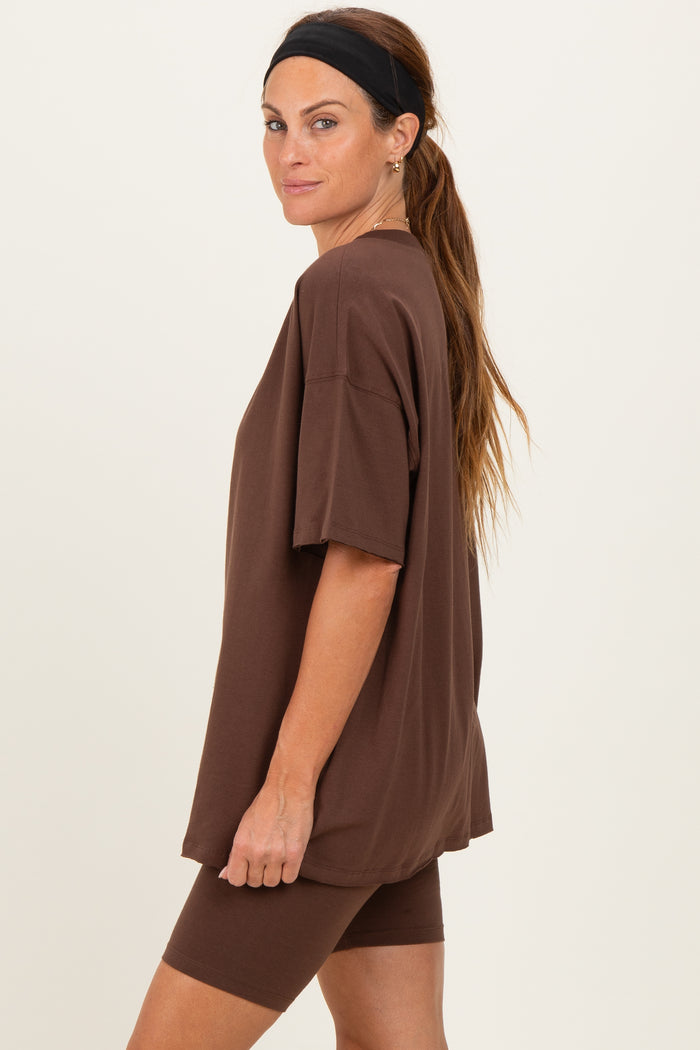 woman wearing a brown oversized t-shirt and matching bike shorts, styled with a headband