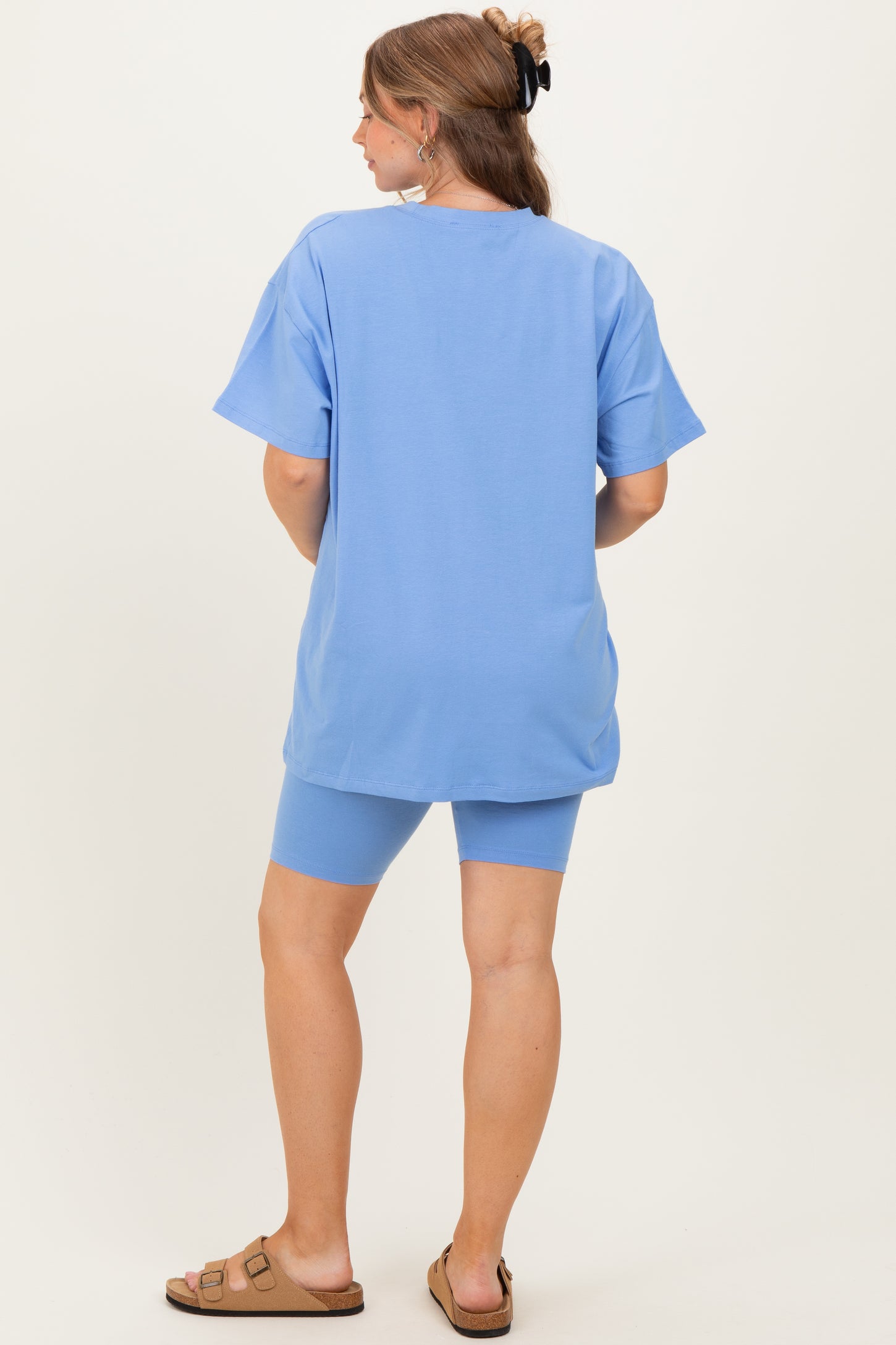 woman wearing a light blue maternity t-shirt and matching bike shorts, seen from the back