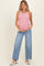 woman wearing a red and white striped maternity tank top and light blue wide-leg maternity jeans, holding her baby bump
