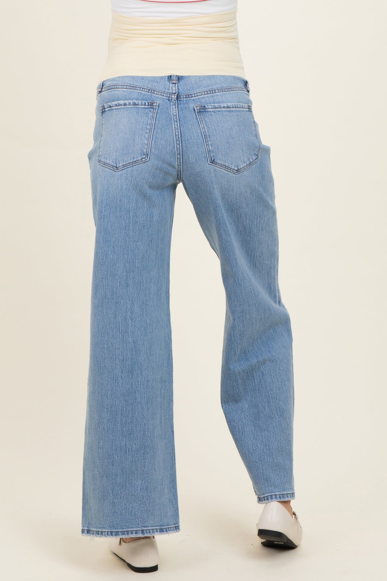 woman wearing light wash maternity jeans with a wide-leg fit, seen from the back