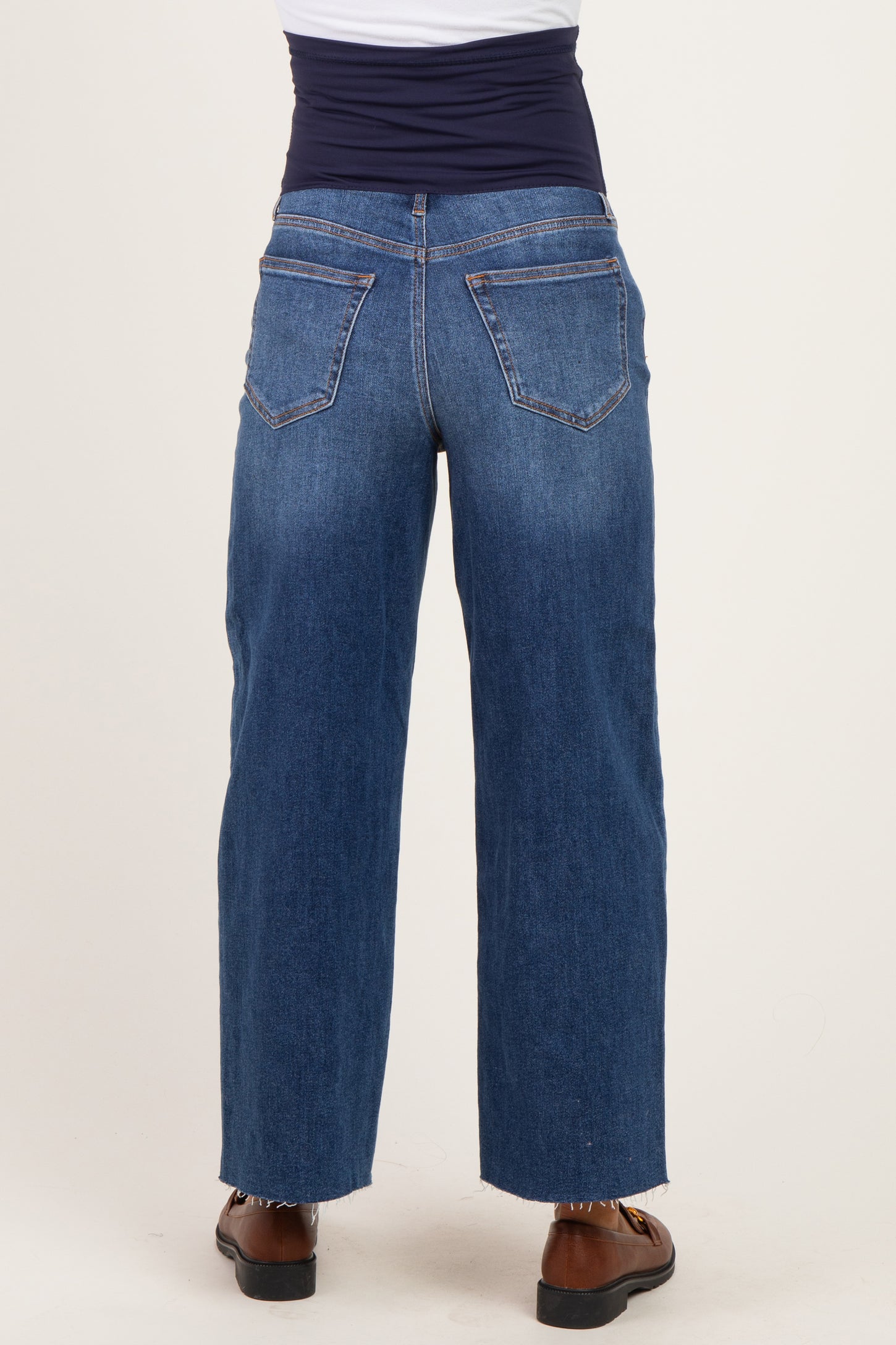 back view of a woman wearing maternity blue wide-leg jeans with a stretchy waistband and a loose fit