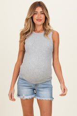 woman wearing a gray sleeveless maternity top and denim shorts, showing her baby bump