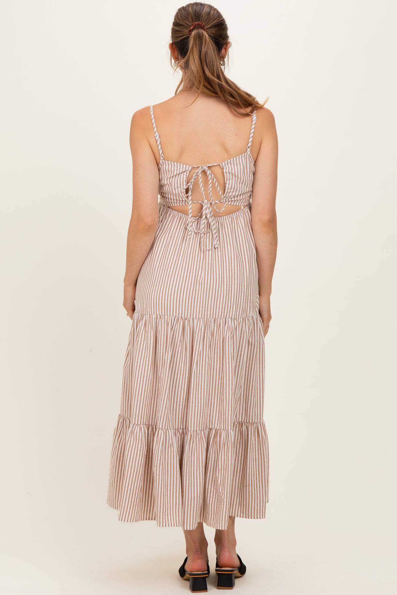 woman wearing a striped back tie maternity maxi dress with tiered ruffle hem