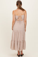 woman wearing a striped back tie maternity maxi dress with tiered ruffle hem