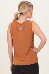 woman wearing an rust orange sleeveless top with a keyhole back detail and a relaxed fit