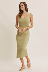 woman wearing a light olive green fitted midi dress with textured detail and adjustable straps
