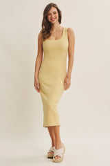 woman wearing a fitted yellow midi dress with floral embroidery and a one-shoulder strap