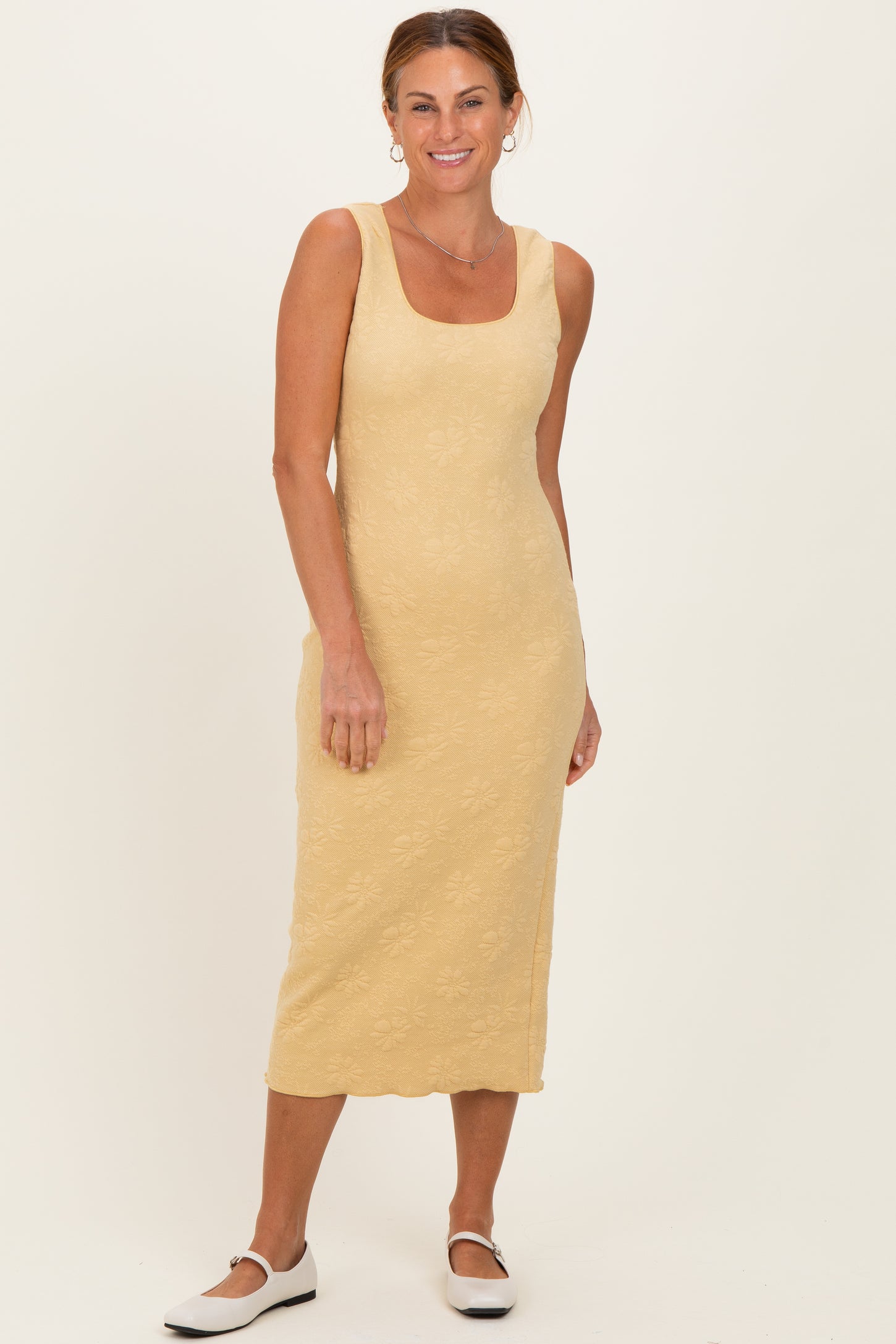 woman wearing a yellow floral midi dress with a square neckline and fitted silhouette