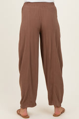 woman wearing brown maternity wide-leg pants, visible elastic waistband and relaxed fit from the back