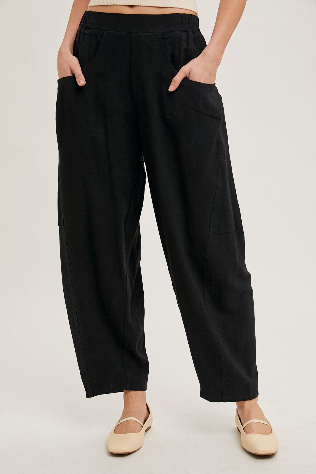 woman wearing black loose-fitting trousers with side pockets and a relaxed silhouette