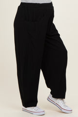 woman wearing black maternity pants with side pockets and a relaxed fit, paired with white sneakers