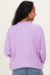 woman wearing a soft lavender maternity sweater with a relaxed fit, viewed from the back