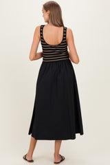 woman wearing a black and striped maternity maxi dress, showing a fitted top and flowing skirt from the back