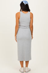 woman wearing a grey sleeveless midi dress, viewed from the back, with a blue patterned headband and casual sneakers