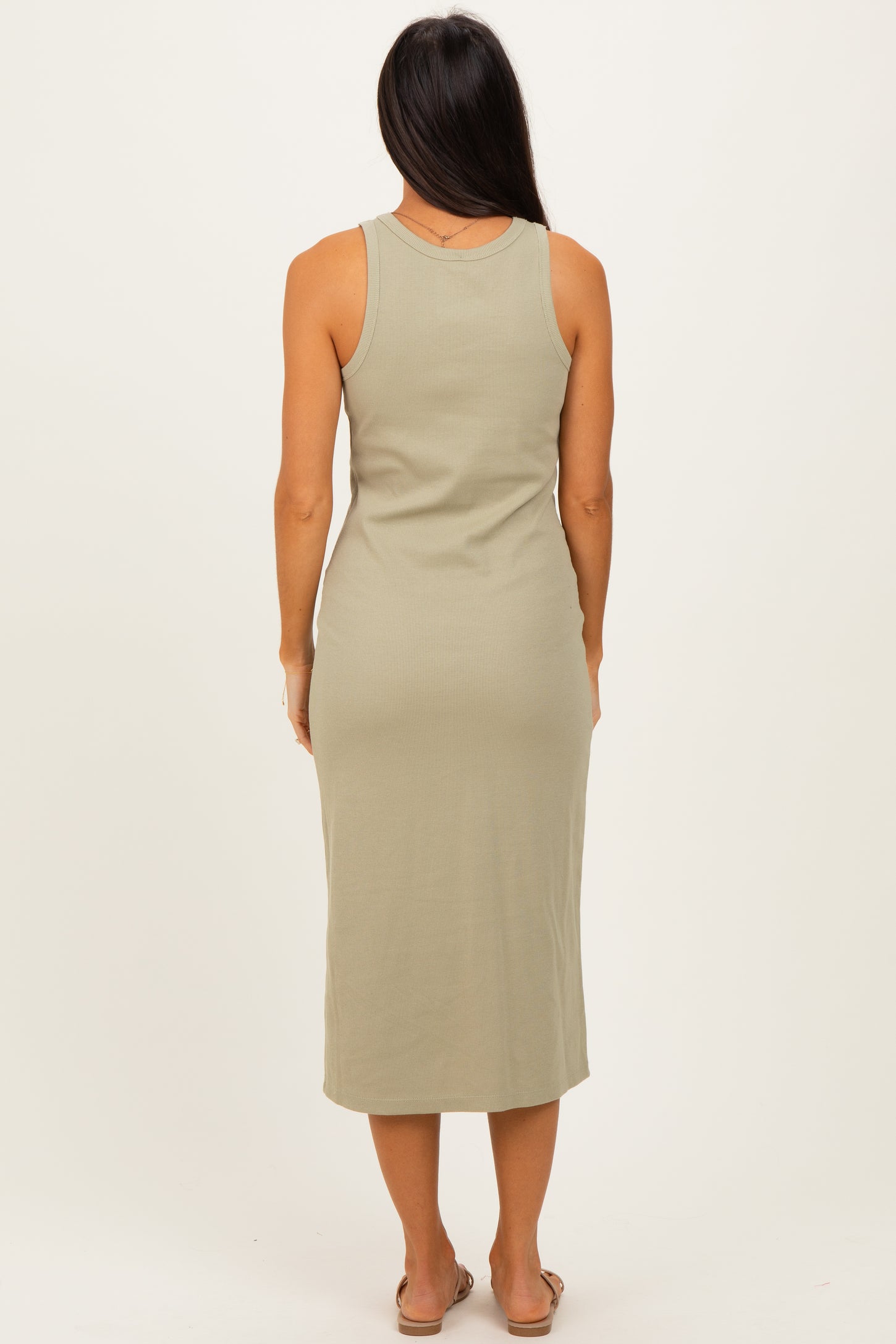 woman wearing a sage green sleeveless midi dress, viewed from the back