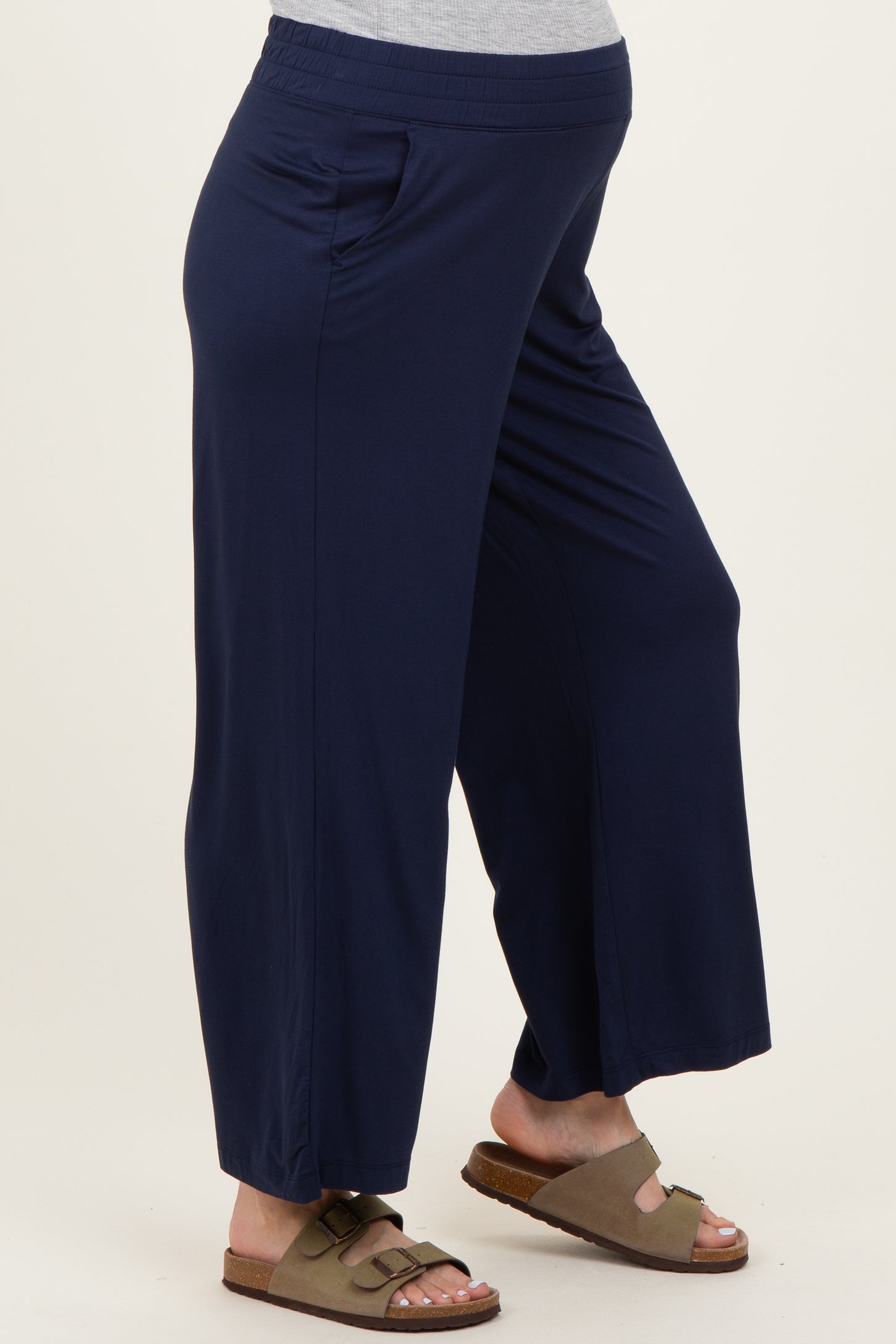 woman wearing navy blue maternity wide-leg pants with side pockets and a comfortable waistband, showing a baby bump