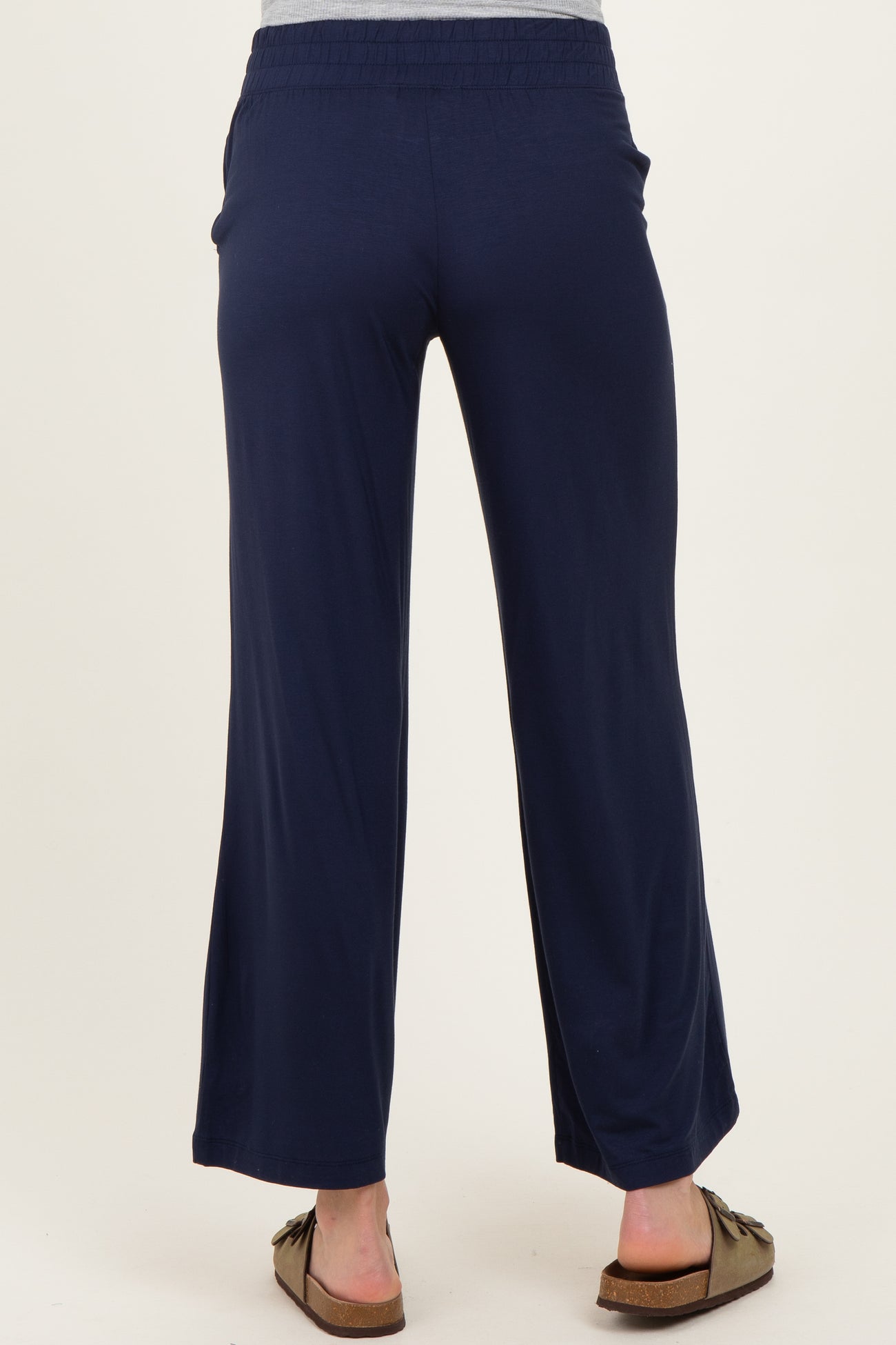 woman wearing navy blue maternity pants with a relaxed fit and wide leg, showing the back view