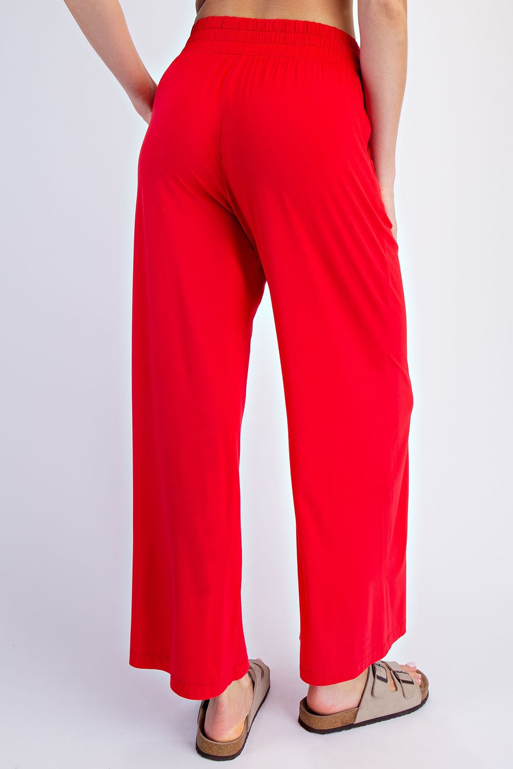 woman wearing red wide-leg pants with an elastic waistband, seen from the back