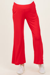 maternity wear in bright red flared pants with pockets, model wearing white sneakers