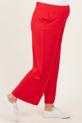 woman wearing bright red maternity pants with side pockets and a comfortable fit, showing her baby bump