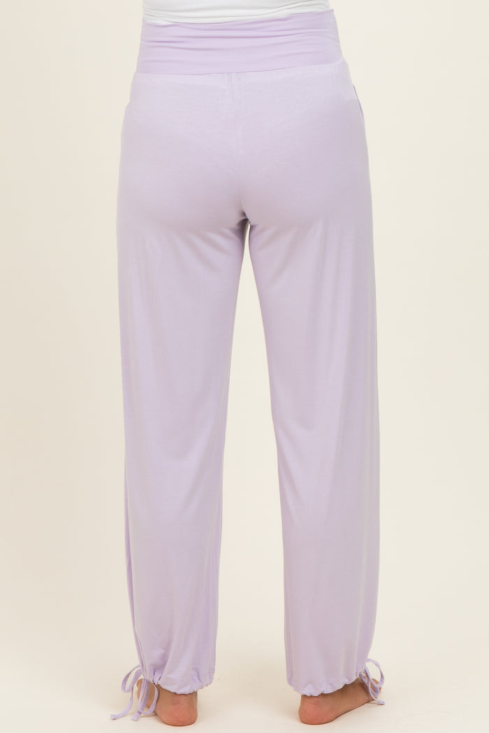 woman wearing lavender maternity pants with a drawstring at the ankles, showing the back view