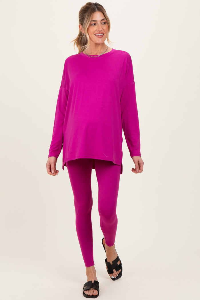 woman wearing a hot pink long sleeve maternity top and matching leggings, showing her baby bump
