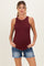 woman wearing a burgundy maternity tank top and denim shorts, highlighting her baby bump
