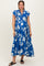 woman wearing a blue floral maternity dress with cap sleeves and tiered skirt, showcasing her baby bump