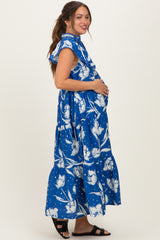 woman wearing a blue floral maxi maternity dress and showing her baby bump