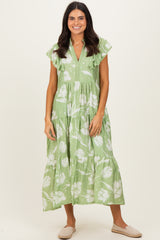 woman wearing a green floral midi dress with ruffle sleeves and a tiered skirt
