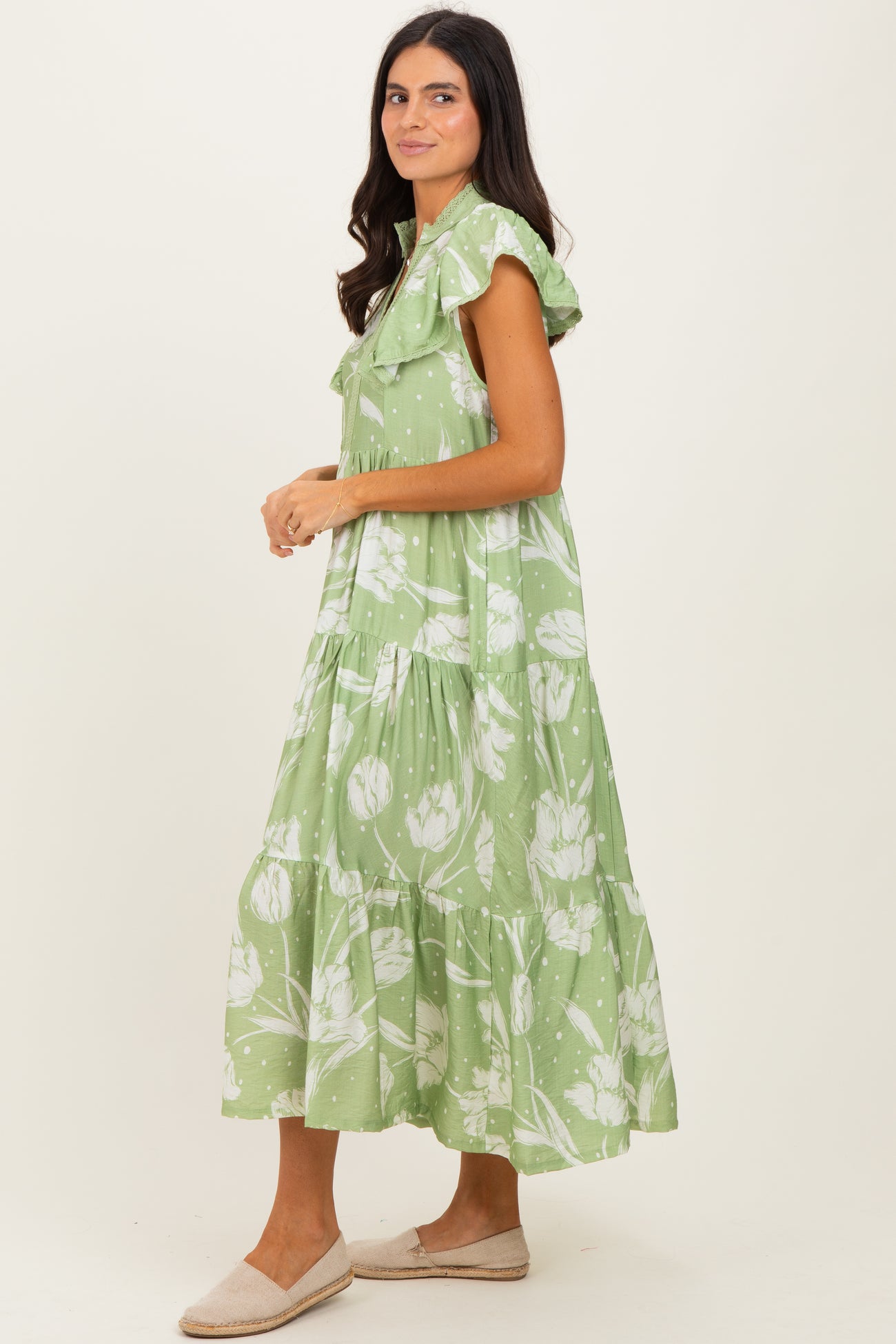 woman wearing a green floral maxi dress with ruffled sleeves and tiered detail