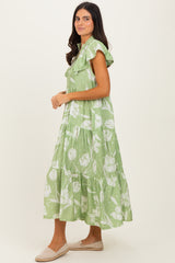 woman wearing a green floral maxi dress with ruffled sleeves and tiered detail