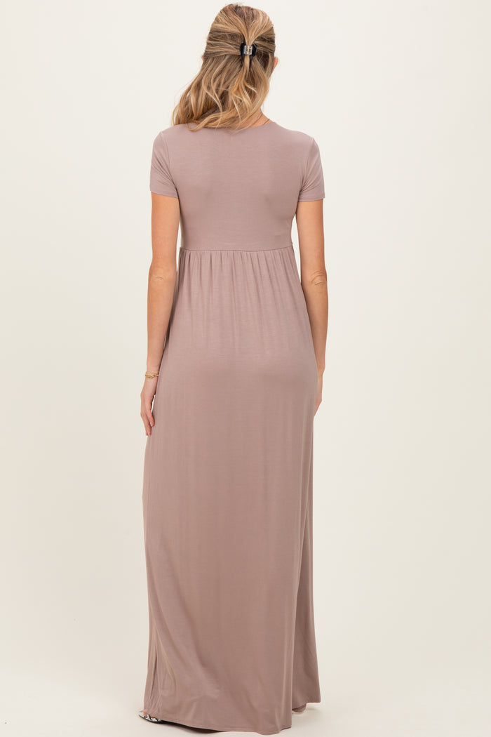 woman wearing a mauve short sleeve maternity maxi dress, showing the back view and a flowing silhouette