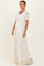 woman wearing a white lace maxi dress with a short sleeve and a yellow ribbon waist tie