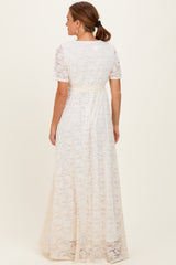 woman wearing a back view of a white lace maxi dress with short sleeves and a fitted waist detail