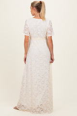 woman wearing a white lace maternity maxi dress with short sleeves and a tied waist, showing the back view