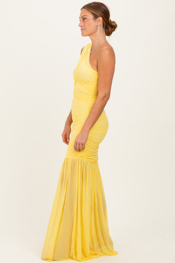 woman wearing a yellow one-shoulder mermaid gown with ruched detailing and a flowing skirt