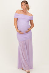 woman wearing a lavender off-the-shoulder maternity dress, showcasing her baby bump with ruched detailing and a flowing skirt