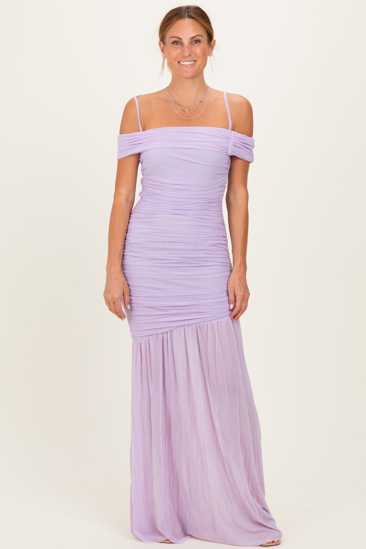 woman wearing a lavender off-the-shoulder ruched maxi dress with a flowing lower skirt