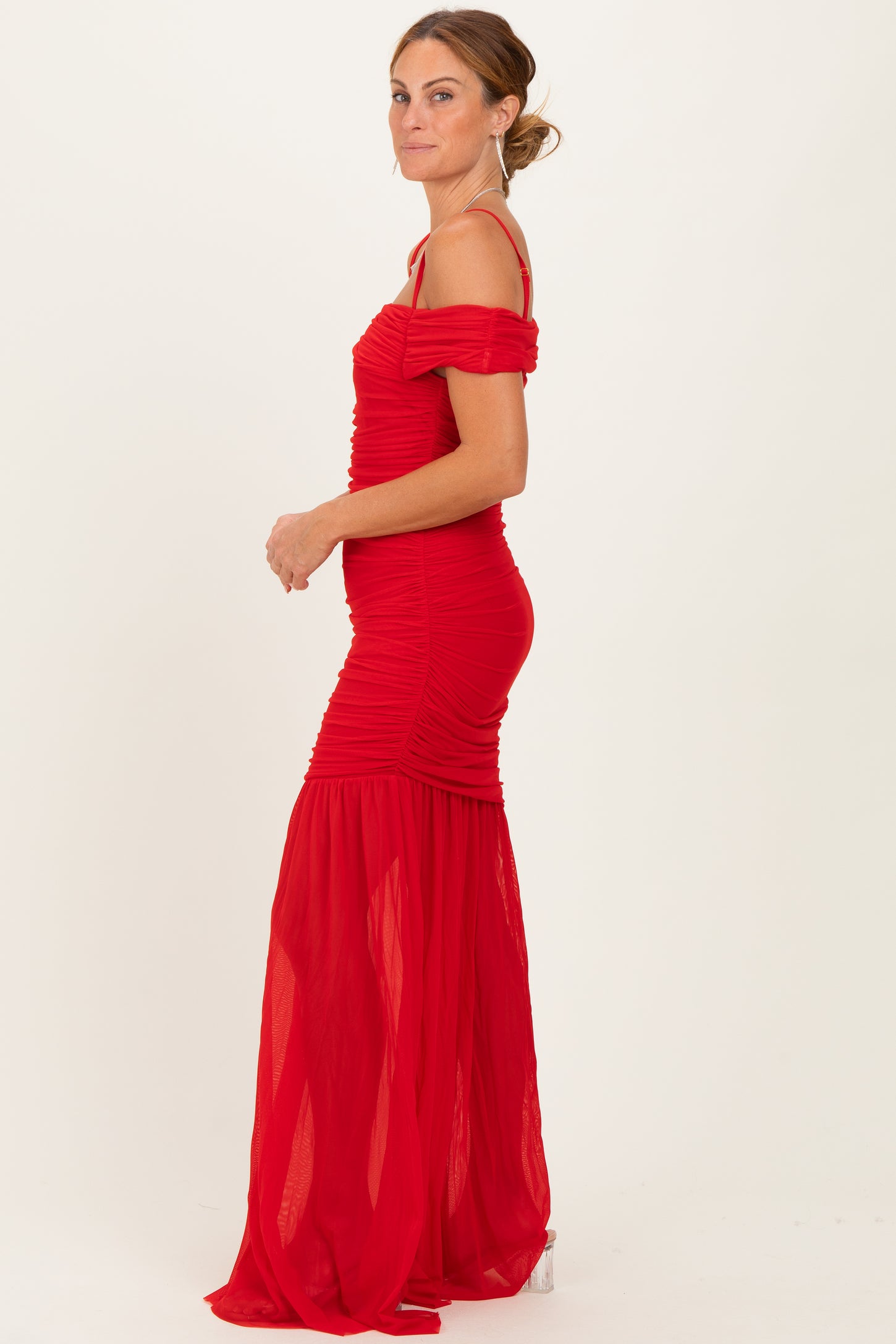 woman wearing a red off-the-shoulder ruched gown with a flowing skirt and fitted bodice