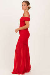 woman wearing a red off-the-shoulder ruched gown with a flowing skirt and fitted bodice